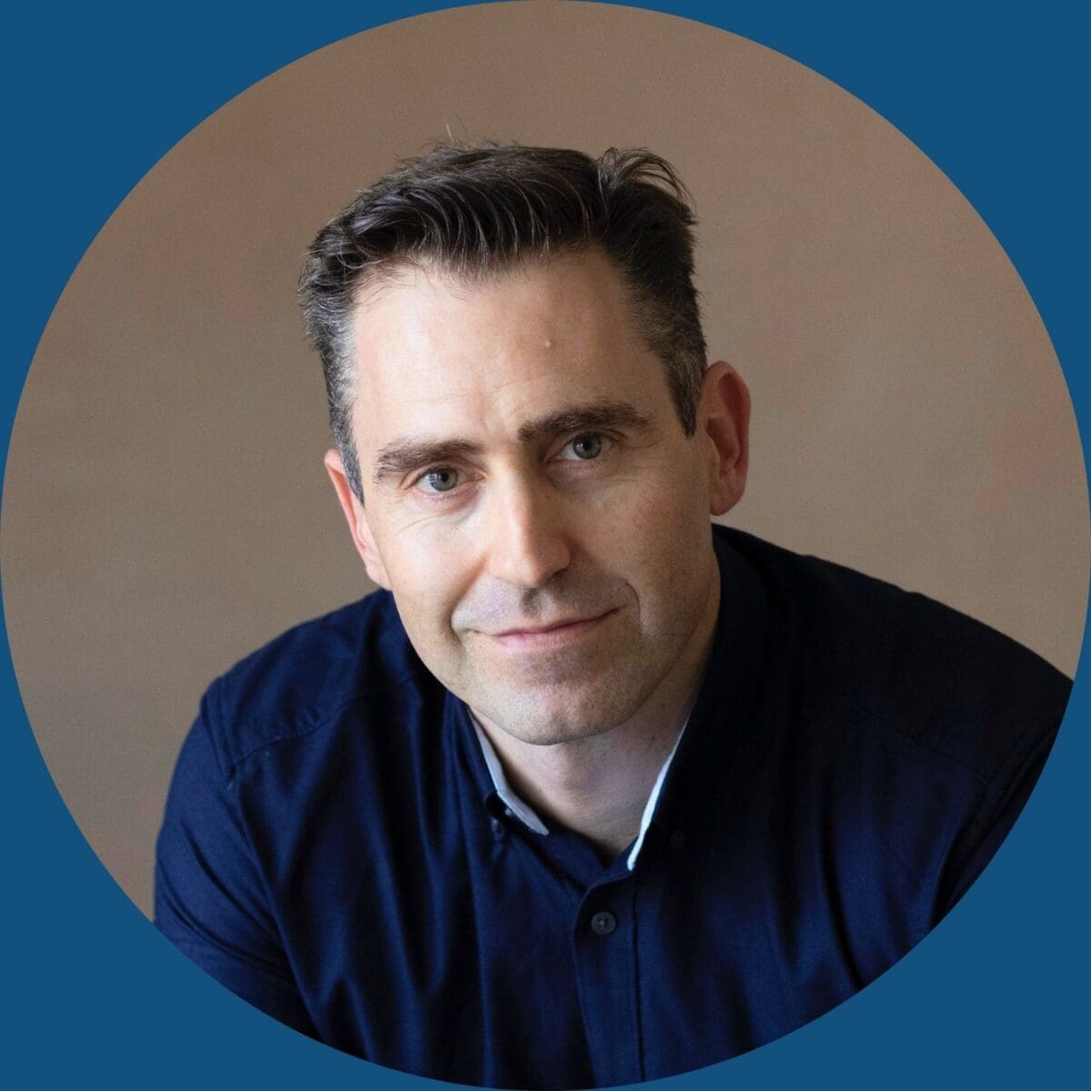 Image of Professor Alex Broom, a man with pale skin, short dark hair and wearing a dark blue collared shirt.